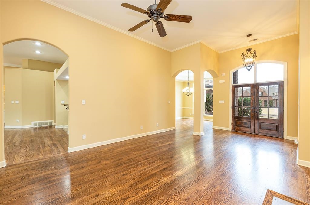 5380 Scarlet Ridge Drive Arlington, TN 38002 - Photo 7 of 35 Spacious room with wood-finish flooring, arched doorways, a decorative ceiling fan, and crown molding