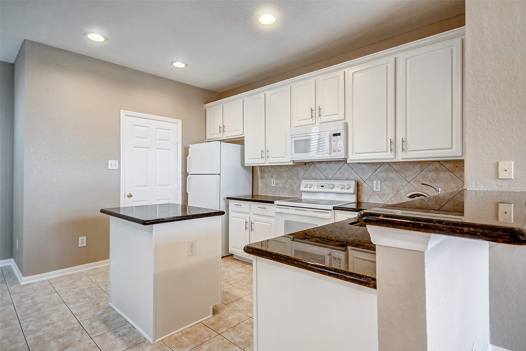 2022 Ridge Wood Lane Sugar Land, TX 77479 - Photo 3 of 21 a kitchen with granite countertop white cabinets and white appliances