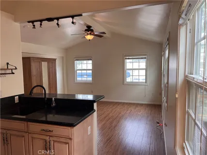 a view of a kitchen with wooden floor and cabinets