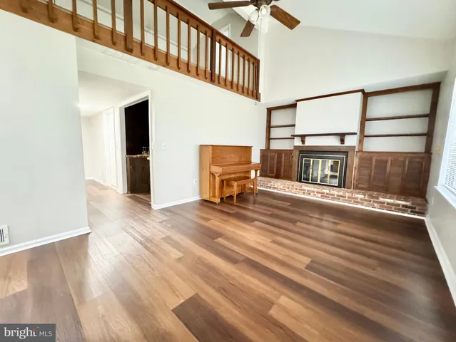 a view of a hallway with wooden floor and a fireplace