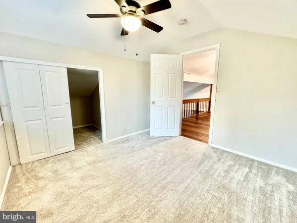 an empty room with closet and fan
