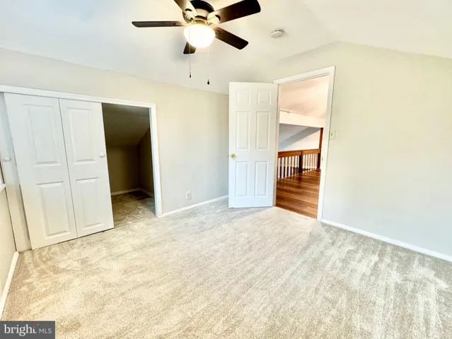 an empty room with closet and fan
