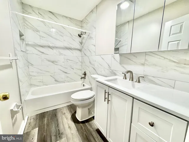 a bathroom with a sink toilet a mirror and shower