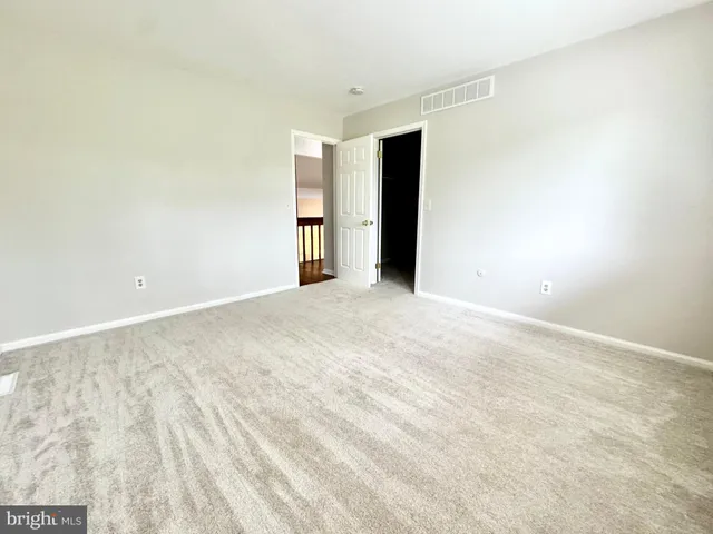a view of an empty room with closet and a window