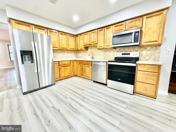 a kitchen with stainless steel appliances a stove microwave and sink