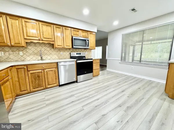 a large kitchen with stainless steel appliances granite countertop a stove and a sink