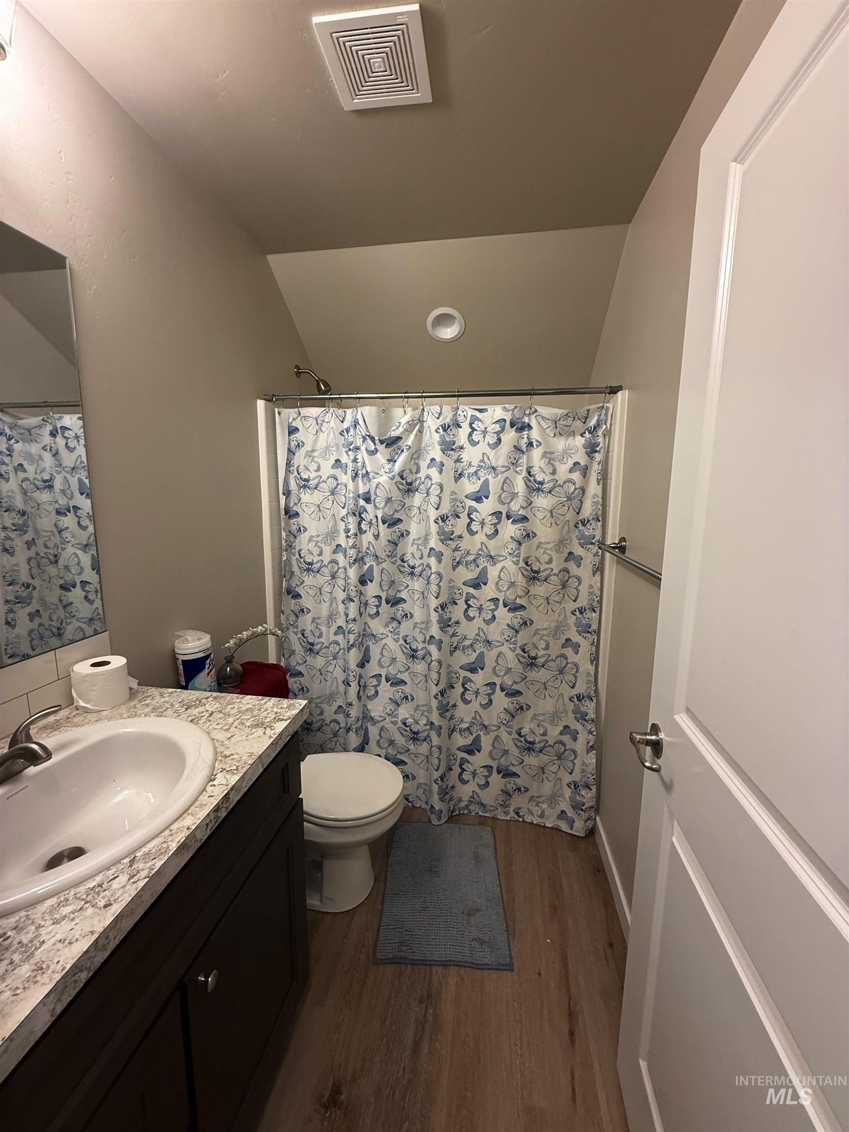 915 Latemar Road Jerome, ID 83338 - Photo 8 of 31 Full bath with dark wood-style flooring, vanity, curtained shower, and vaulted ceiling