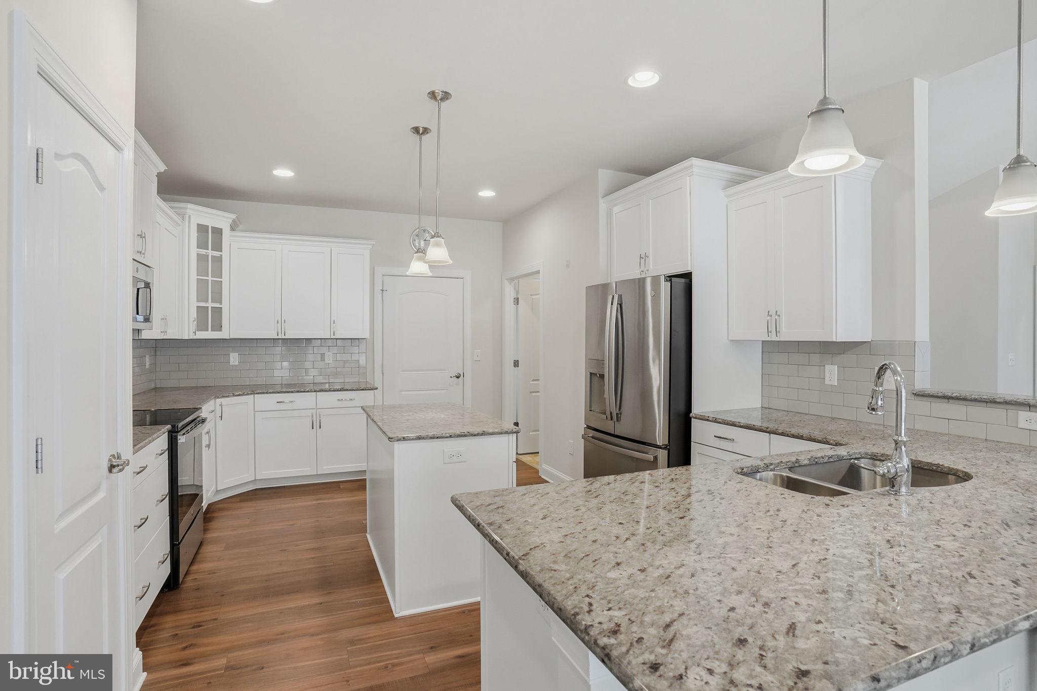 18822 Melville Way Georgetown, DE 19947 - Photo 14 of 24 a kitchen with a sink a counter top space stainless steel appliances and cabinets