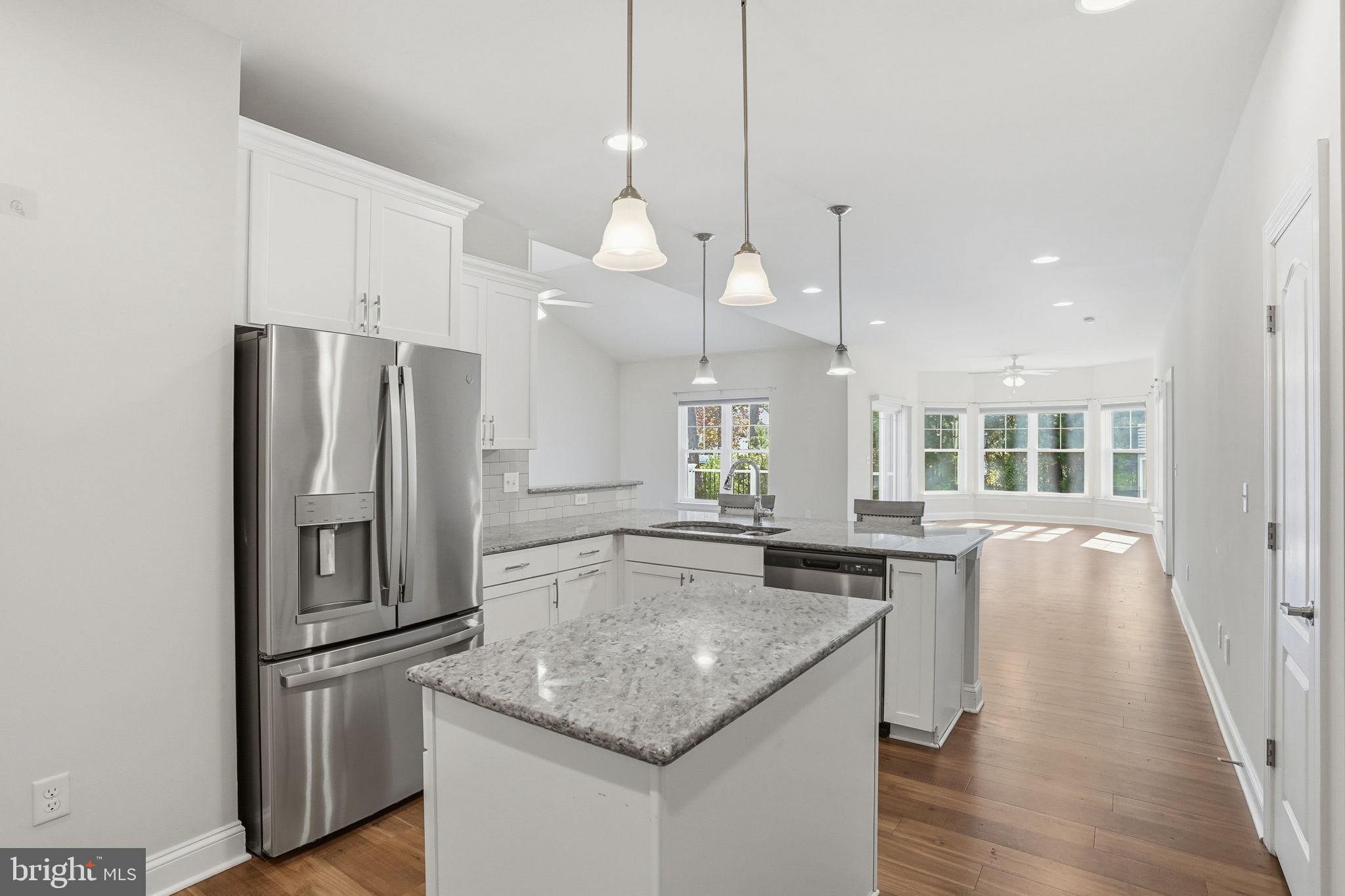 18822 Melville Way Georgetown, DE 19947 - Photo 2 of 24 a kitchen with stainless steel appliances granite countertop a refrigerator a sink a stove and a wooden floors