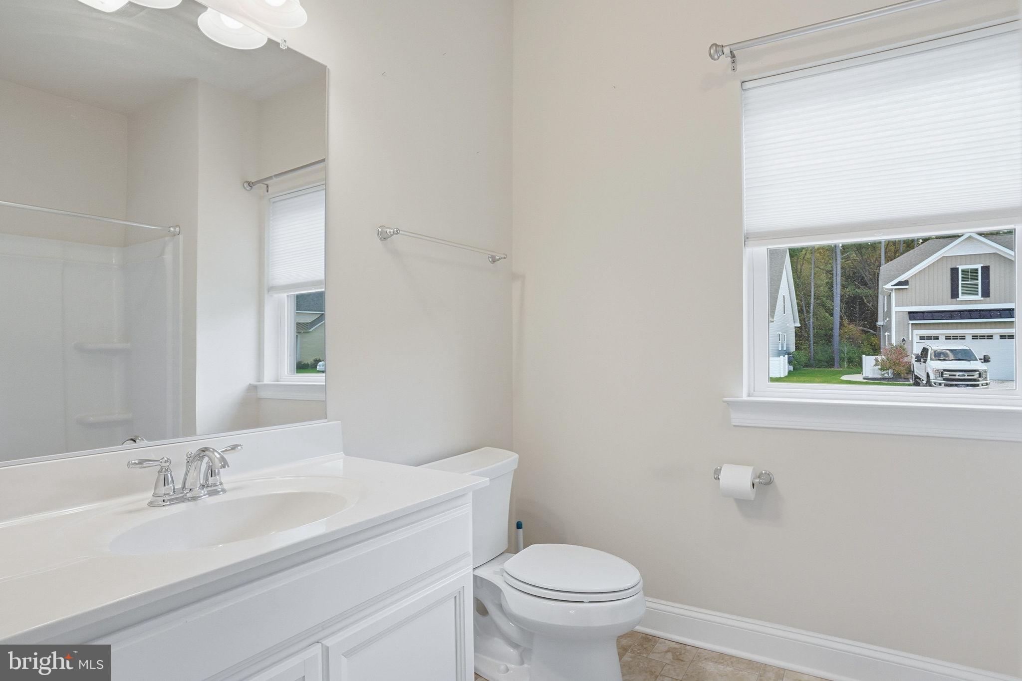18822 Melville Way Georgetown, DE 19947 - Photo 9 of 24 a bathroom with a toilet a sink and mirror