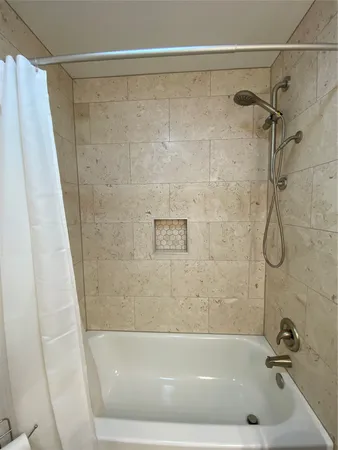an empty room with a bathroom and chandelier