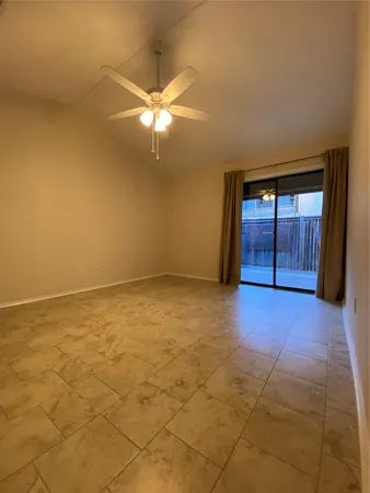 a view of an empty room with a chandelier fan