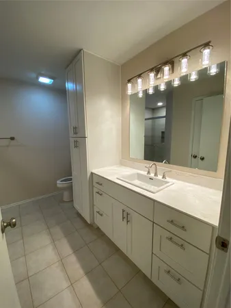 a bathroom with a toilet sink and mirror