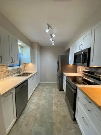 a large kitchen with kitchen island a sink stainless steel appliances and cabinets