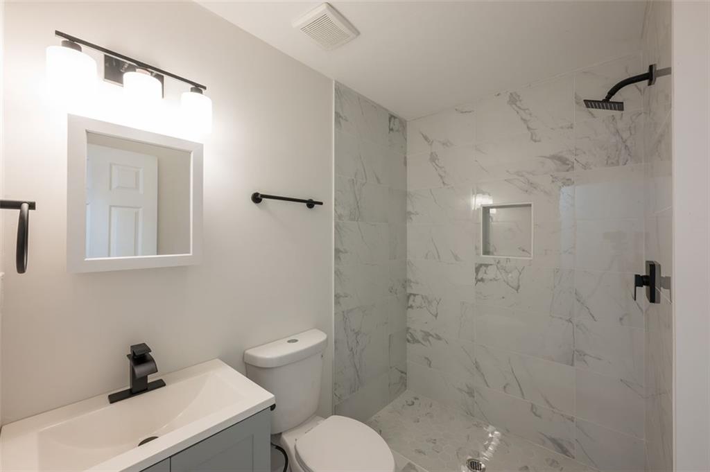 2027 Lois Place Northwest, Unit A Atlanta, GA 30318 - Photo 18 of 23 a bathroom with a toilet sink and shower