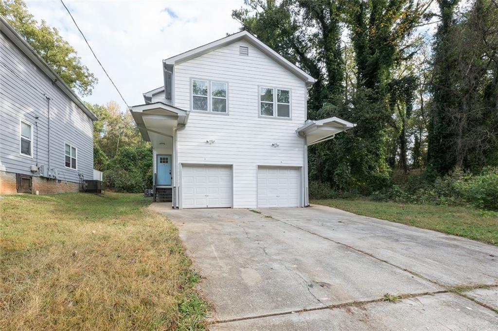 2027 Lois Place Northwest, Unit A Atlanta, GA 30318 - Photo 2 of 23 a view of a house with a yard and garage