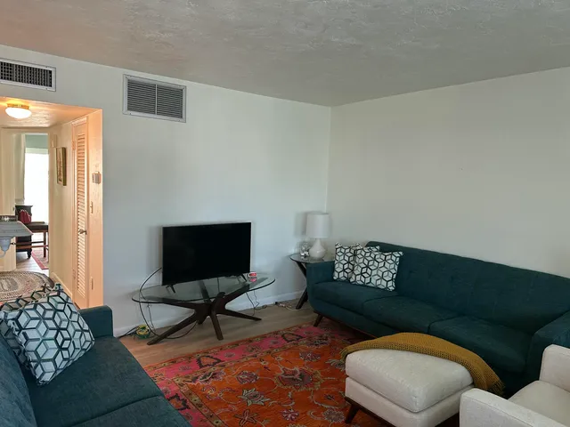 a living room with furniture and a painting on the wall
