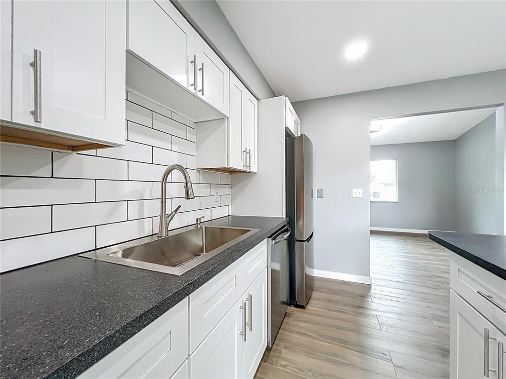 6848 Compass Court Orlando, FL 32810 - Photo 11 of 47 a kitchen with a sink and a refrigerator
