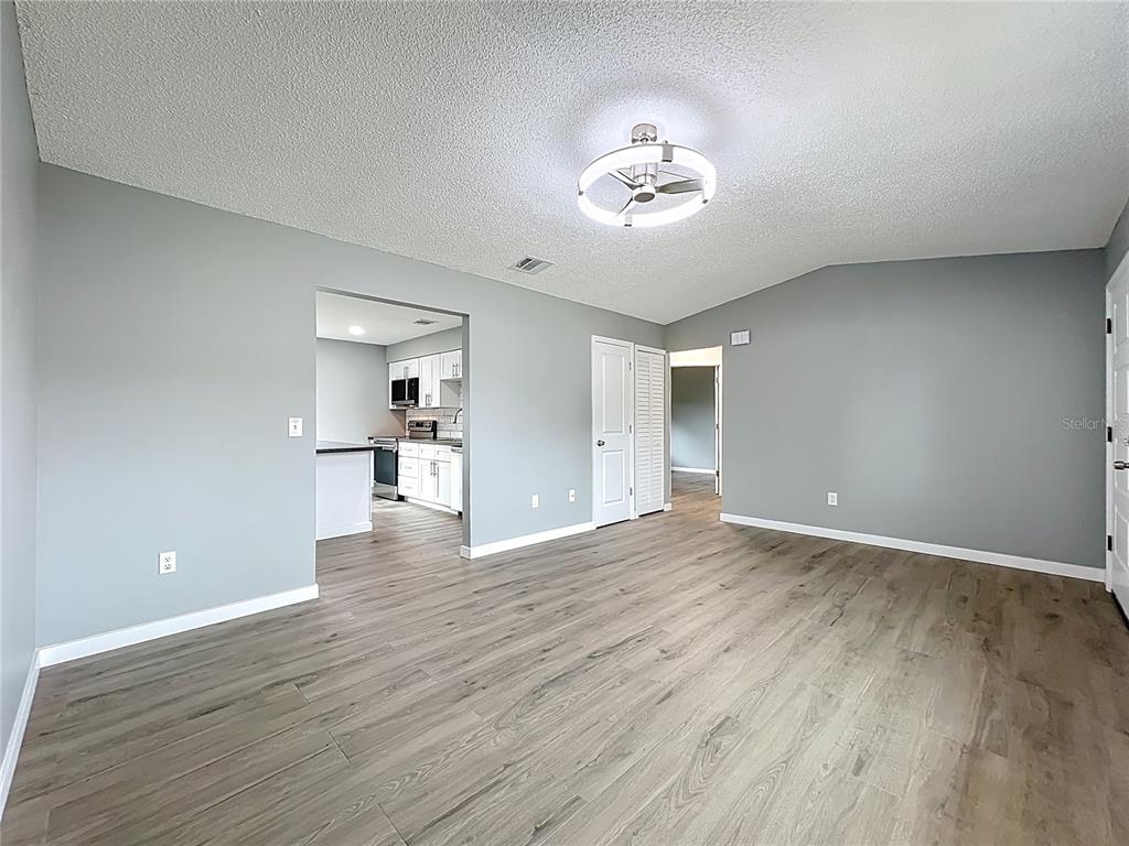 6848 Compass Court Orlando, FL 32810 - Photo 12 of 47 a view of empty room with wooden floor