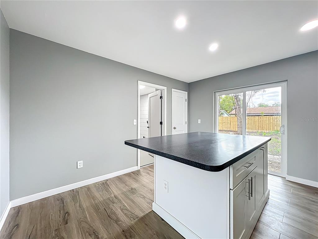 6848 Compass Court Orlando, FL 32810 - Photo 15 of 47 a room with a table chairs and wooden floor