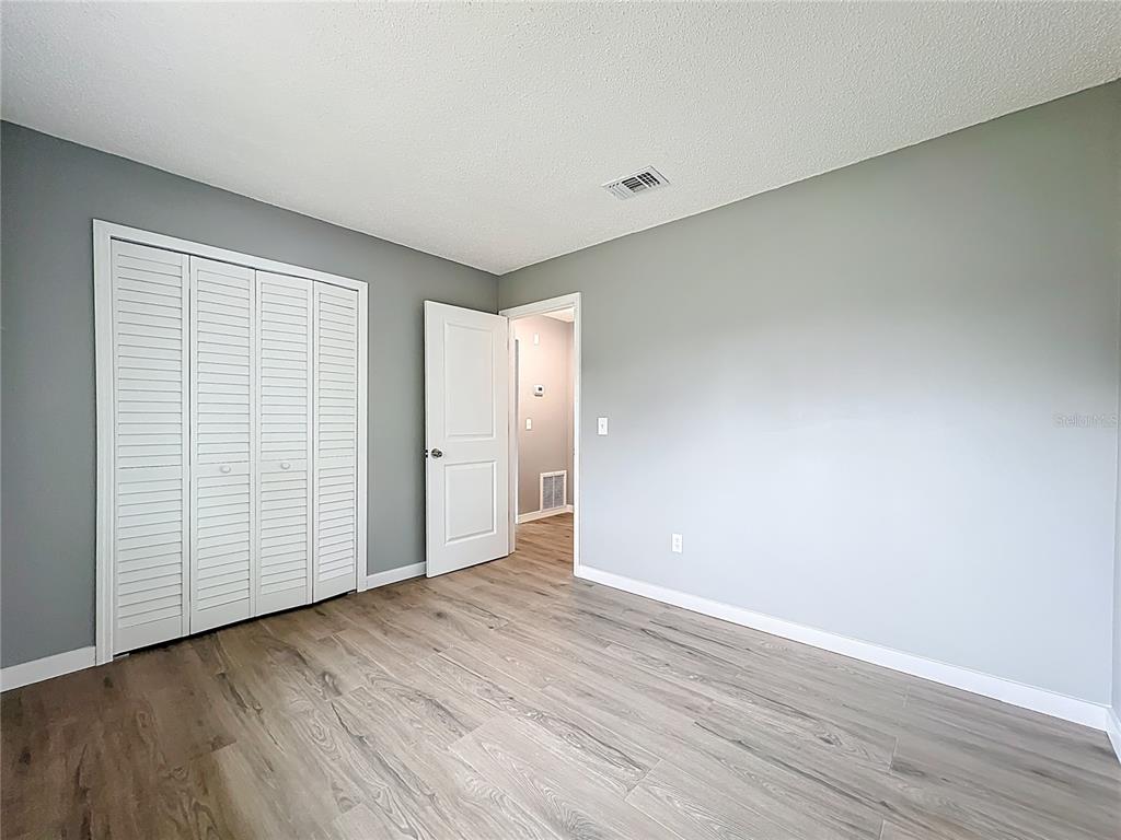 6848 Compass Court Orlando, FL 32810 - Photo 19 of 47 a view of an empty room with wooden floor