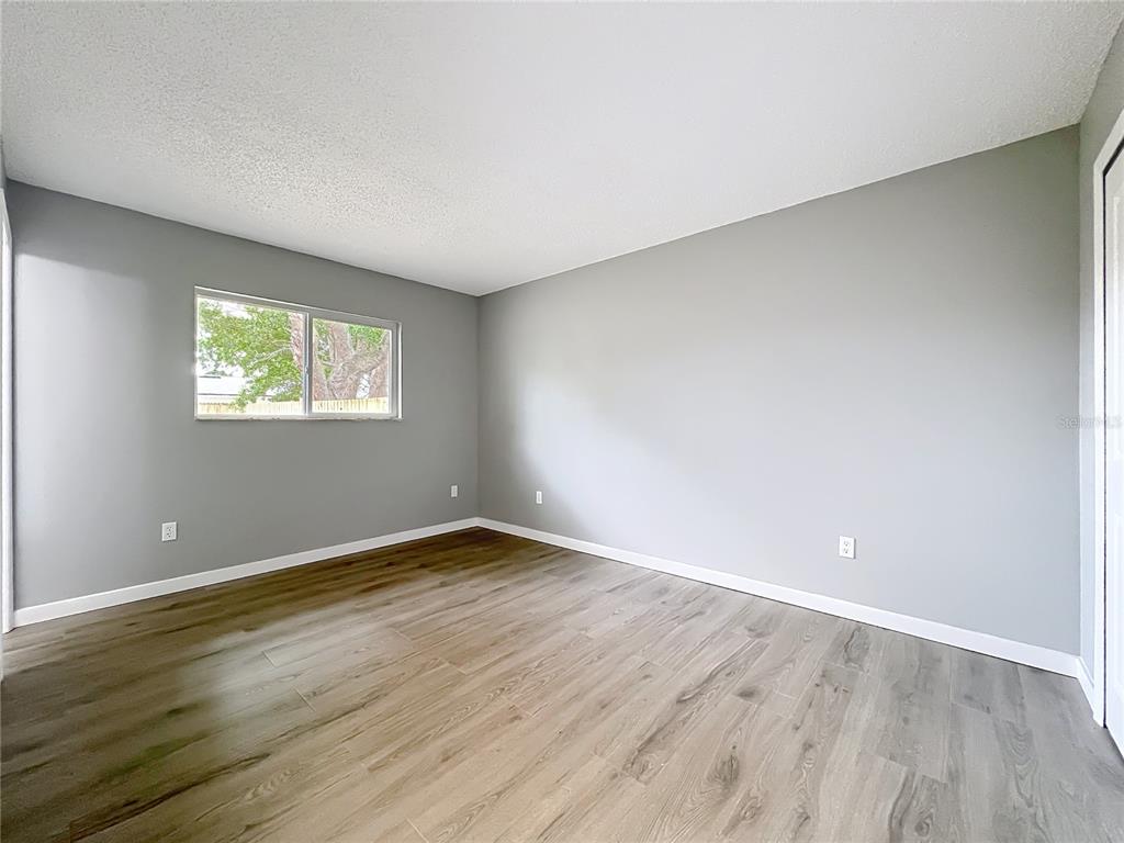 6848 Compass Court Orlando, FL 32810 - Photo 21 of 47 a view of an empty room with wooden floor and a window