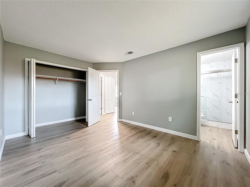 6848 Compass Court Orlando, FL 32810 - Photo 22 of 47 a view of an empty room with wooden floor and closet