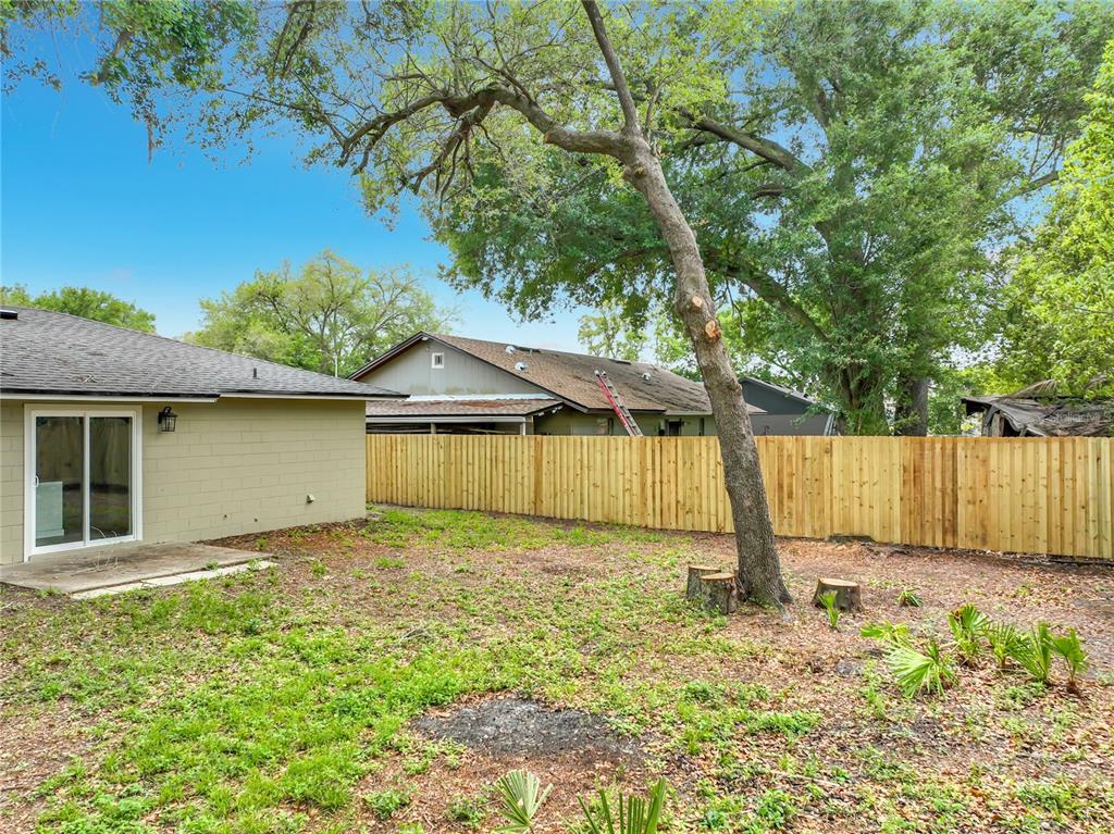 6848 Compass Court Orlando, FL 32810 - Photo 37 of 47 a backyard of a house with lots of green space