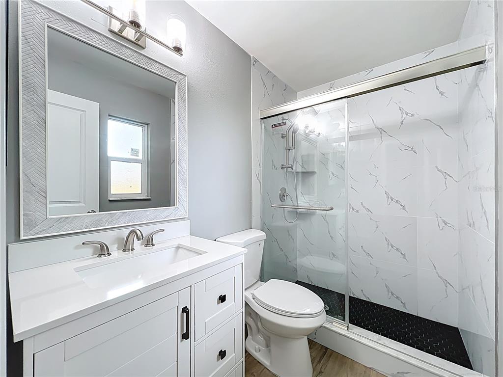 6848 Compass Court Orlando, FL 32810 - Photo 4 of 47 a bathroom with a sink a toilet and shower