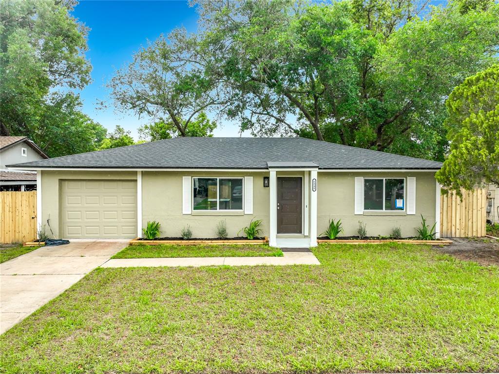 6848 Compass Court Orlando, FL 32810 - Photo 44 of 47 a front view of a house with a garden and trees