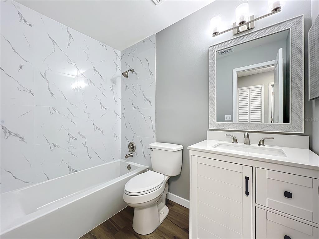 6848 Compass Court Orlando, FL 32810 - Photo 9 of 47 a bathroom with a toilet sink vanity tub and shower
