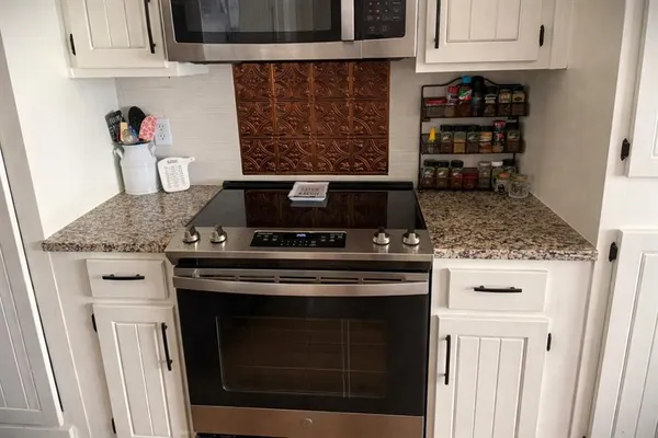 a stove top oven sitting inside of a kitchen