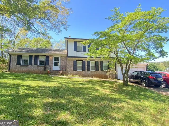 a front view of a house with a garden
