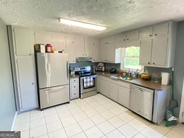 a kitchen with stainless steel appliances a refrigerator sink and cabinets