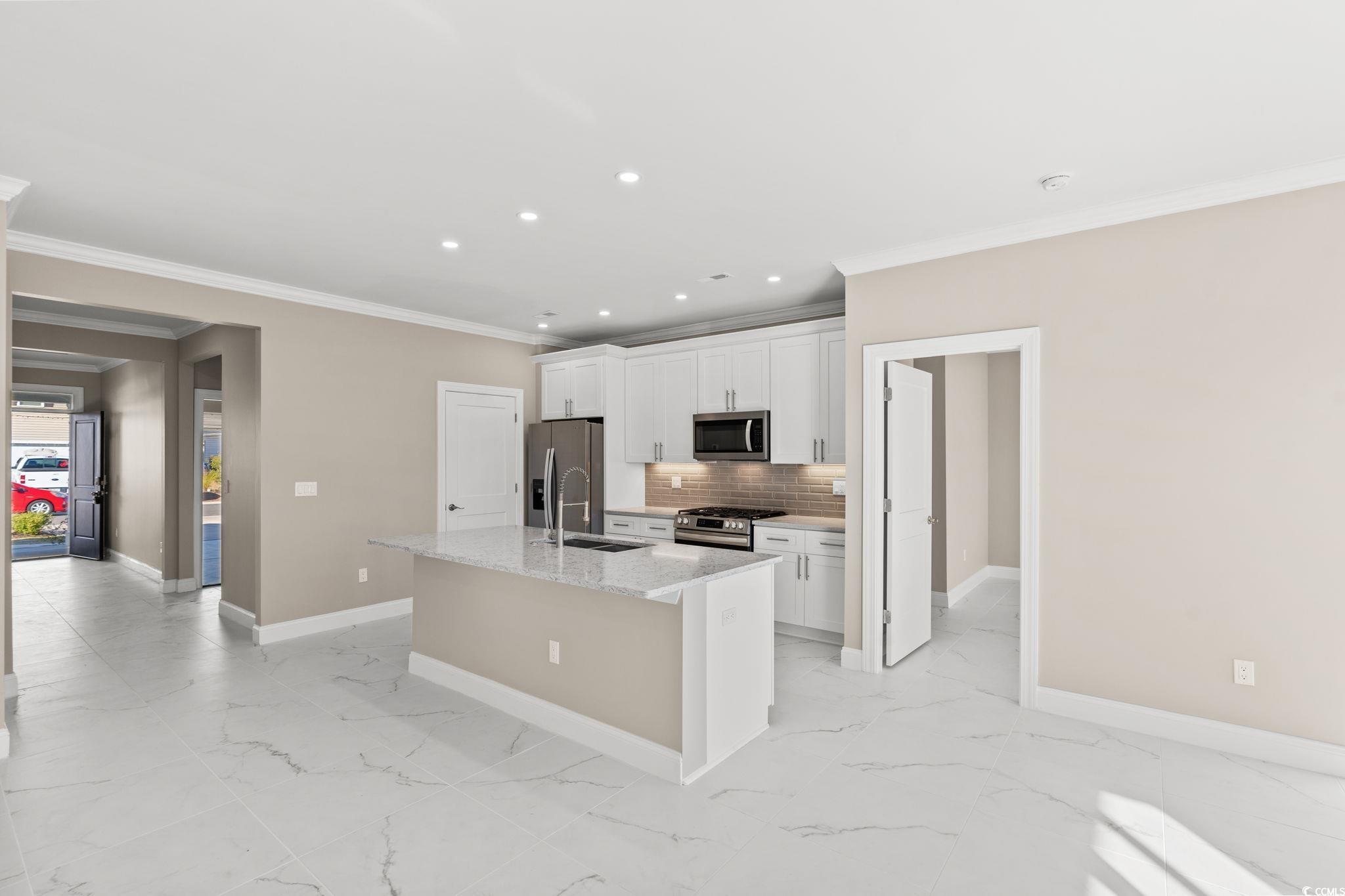 600 Table Rock Court Myrtle Beach, SC 29579 - Photo 11 of 37 Kitchen with crown molding, a kitchen island with sink, white cabinetry, recessed lighting, and stainless steel appliances