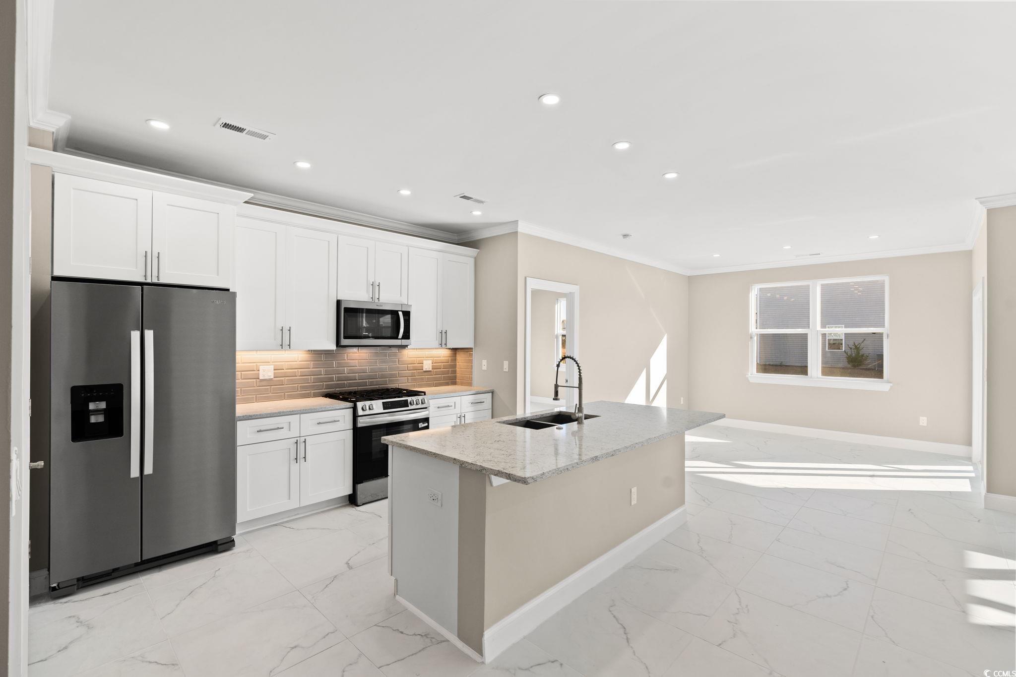 600 Table Rock Court Myrtle Beach, SC 29579 - Photo 12 of 37 Kitchen featuring stainless steel appliances, recessed lighting, an island with sink, light stone countertops, and crown molding