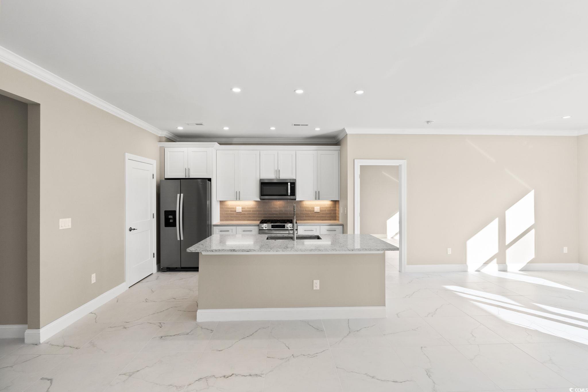 600 Table Rock Court Myrtle Beach, SC 29579 - Photo 14 of 37 Kitchen featuring light stone countertops, stainless steel appliances, recessed lighting, ornamental molding, and a center island with sink