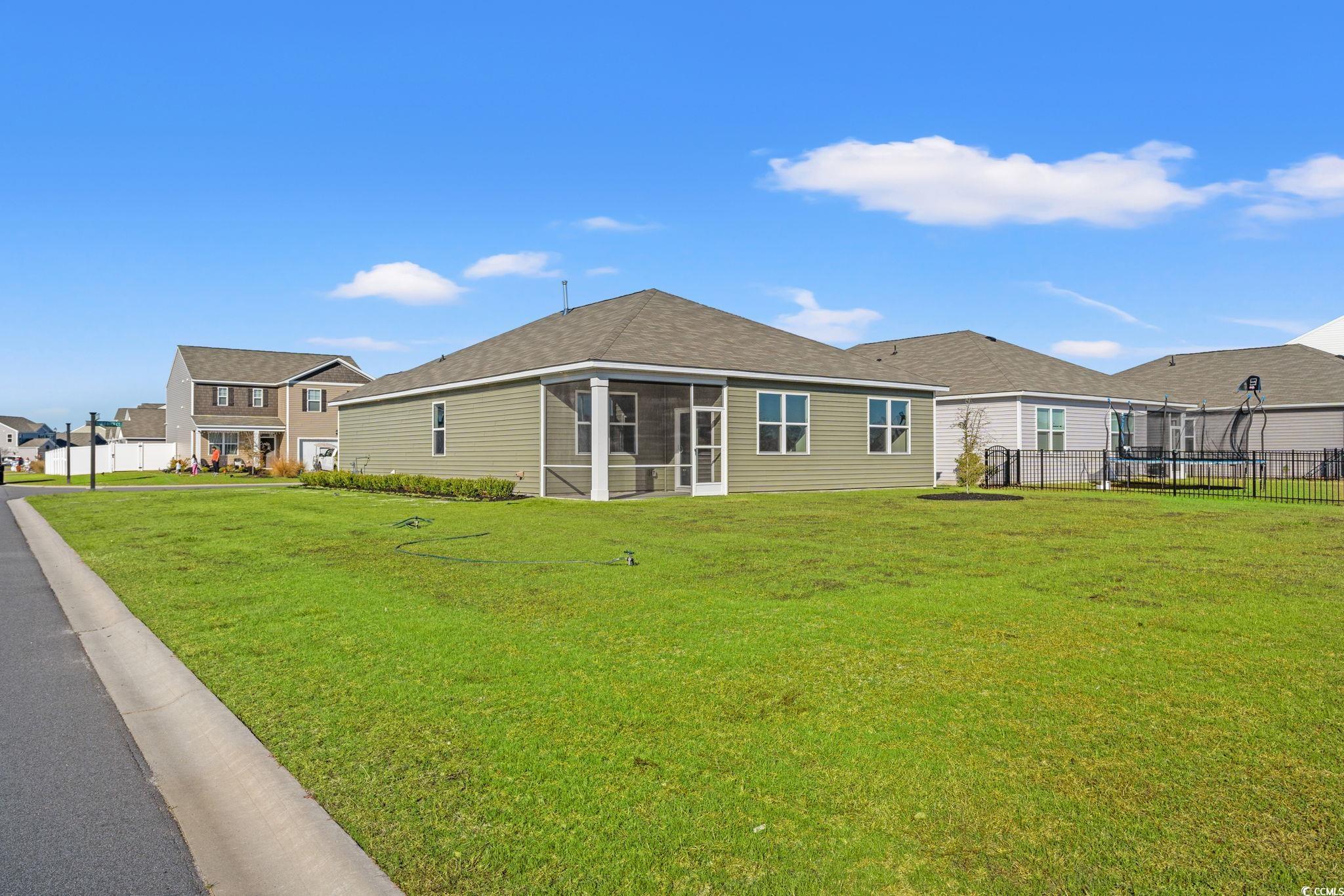 600 Table Rock Court Myrtle Beach, SC 29579 - Photo 31 of 37 Rear view of house featuring a sunroom, a trampoline, and a shingled roof