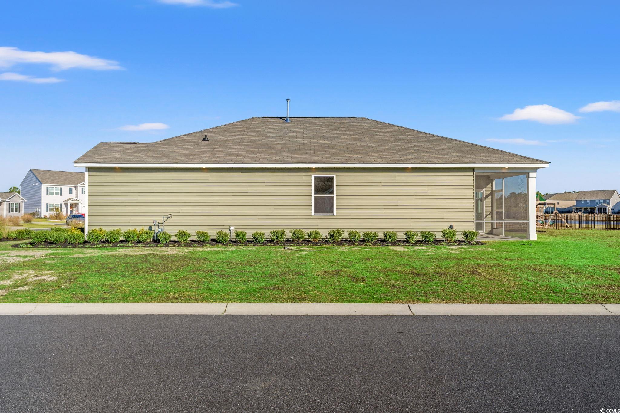 600 Table Rock Court Myrtle Beach, SC 29579 - Photo 32 of 37 View of side of home featuring a yard, roof with shingles, and a sunroom