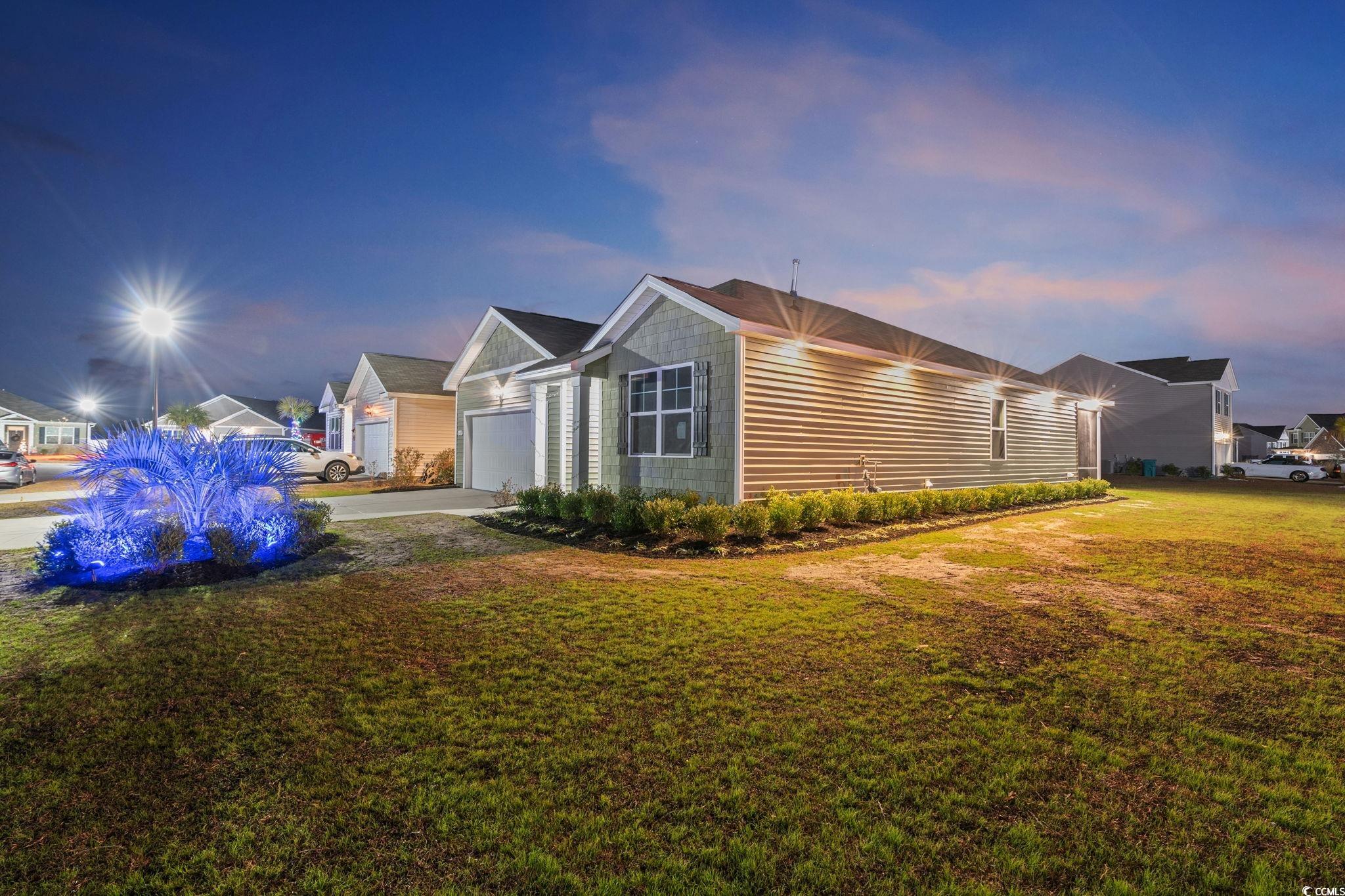 600 Table Rock Court Myrtle Beach, SC 29579 - Photo 4 of 37 Property exterior at dusk with a yard, concrete driveway, and a garage