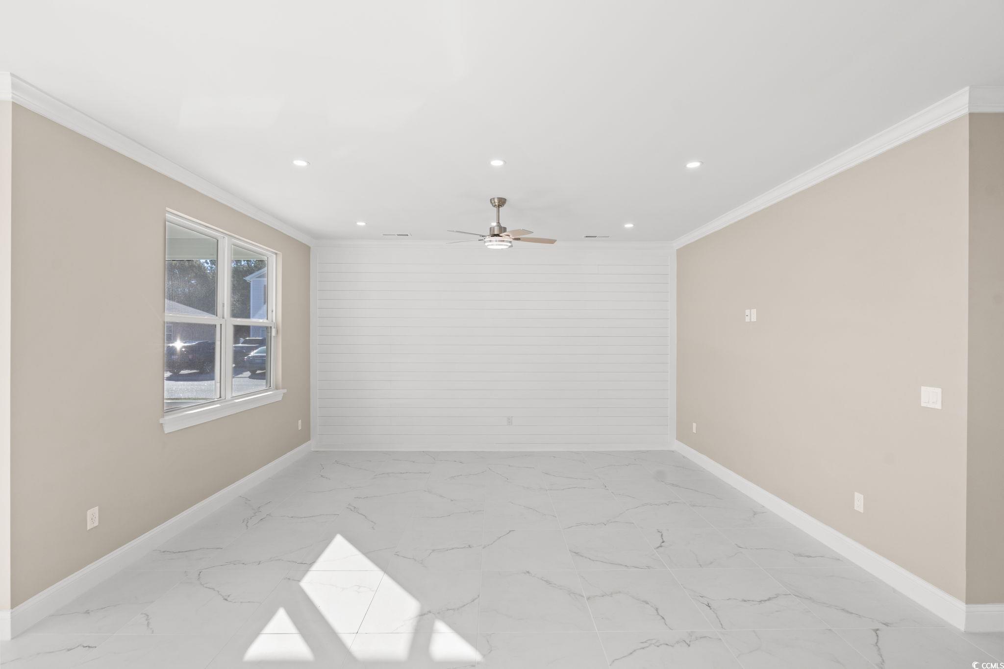 600 Table Rock Court Myrtle Beach, SC 29579 - Photo 8 of 37 Spare room featuring light marble finish flooring, ornamental molding, recessed lighting, ceiling fan, and wood walls