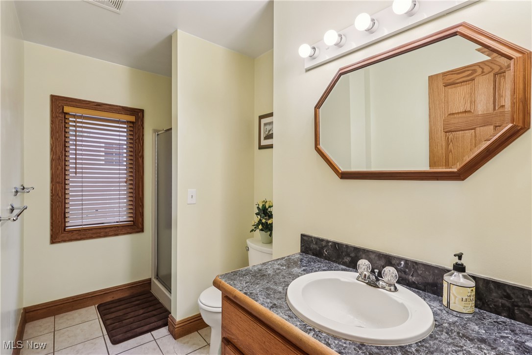 337 Cedar Point Road Sandusky, OH 44870 - Photo 20 of 50 Full bath featuring vanity, light tile patterned floors, and a stall shower