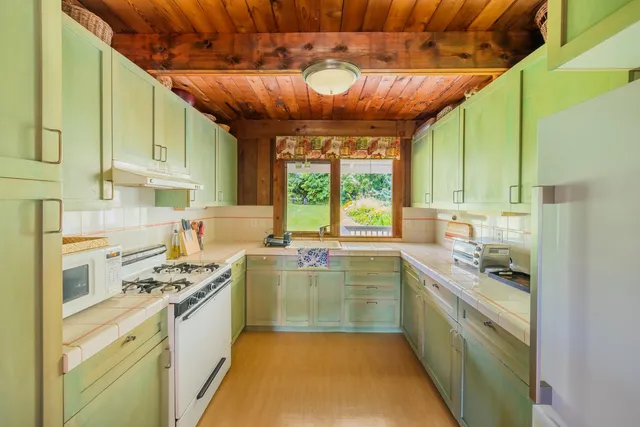 a kitchen with kitchen island granite countertop lots of counter top space and stainless steel appliances