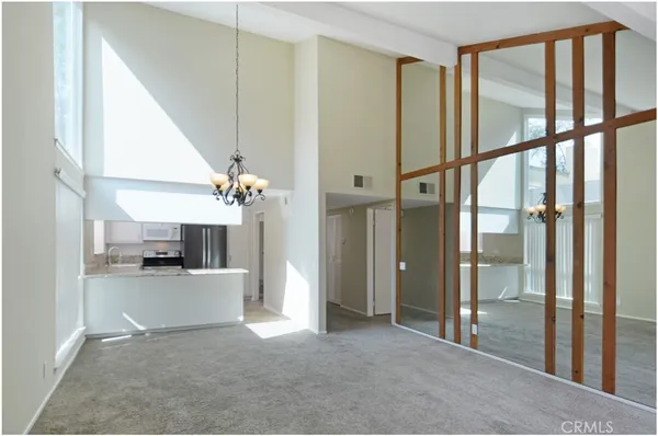 a view of a hallway with a dining table chairs