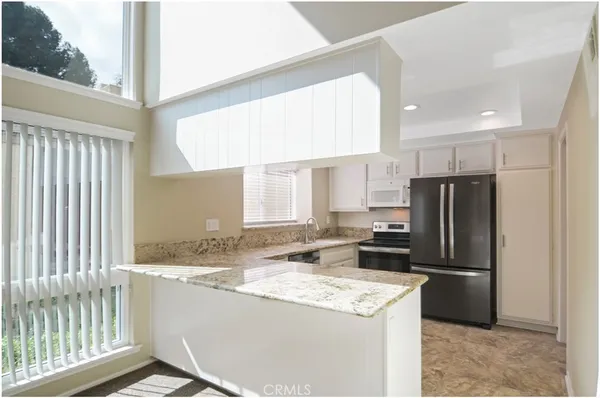 a kitchen with a refrigerator a stove a sink and a window