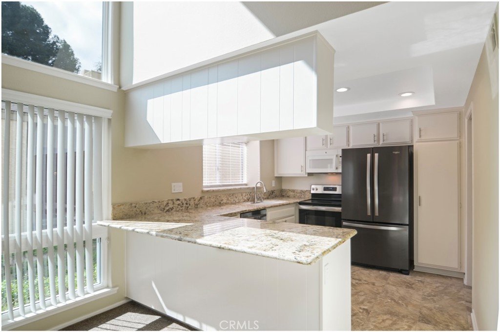 24802 Leto Circle Mission Viejo, CA 92691 - Photo 12 of 27 a kitchen with a refrigerator a stove a sink and a window