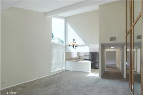 a view of a kitchen with white cabinets and stainless steel appliances