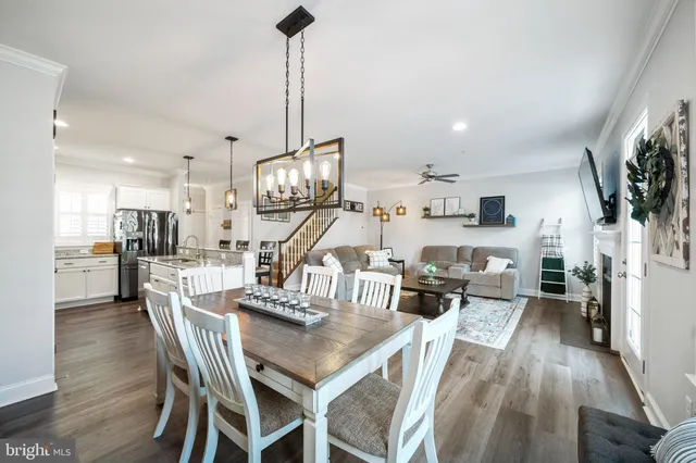a view of a dining room and livingroom with furniture wooden floor a rug