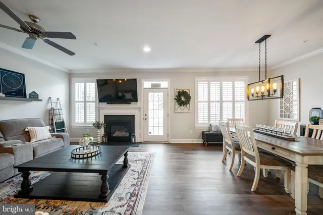 a living room with furniture a fireplace a flat screen tv and windows