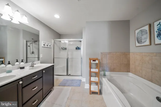a spacious bathroom with a tub sink shower and mirror